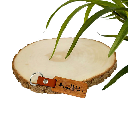 Handmade African keychain displayed on a wooden slice, showcasing unique craftsmanship from local artisans.