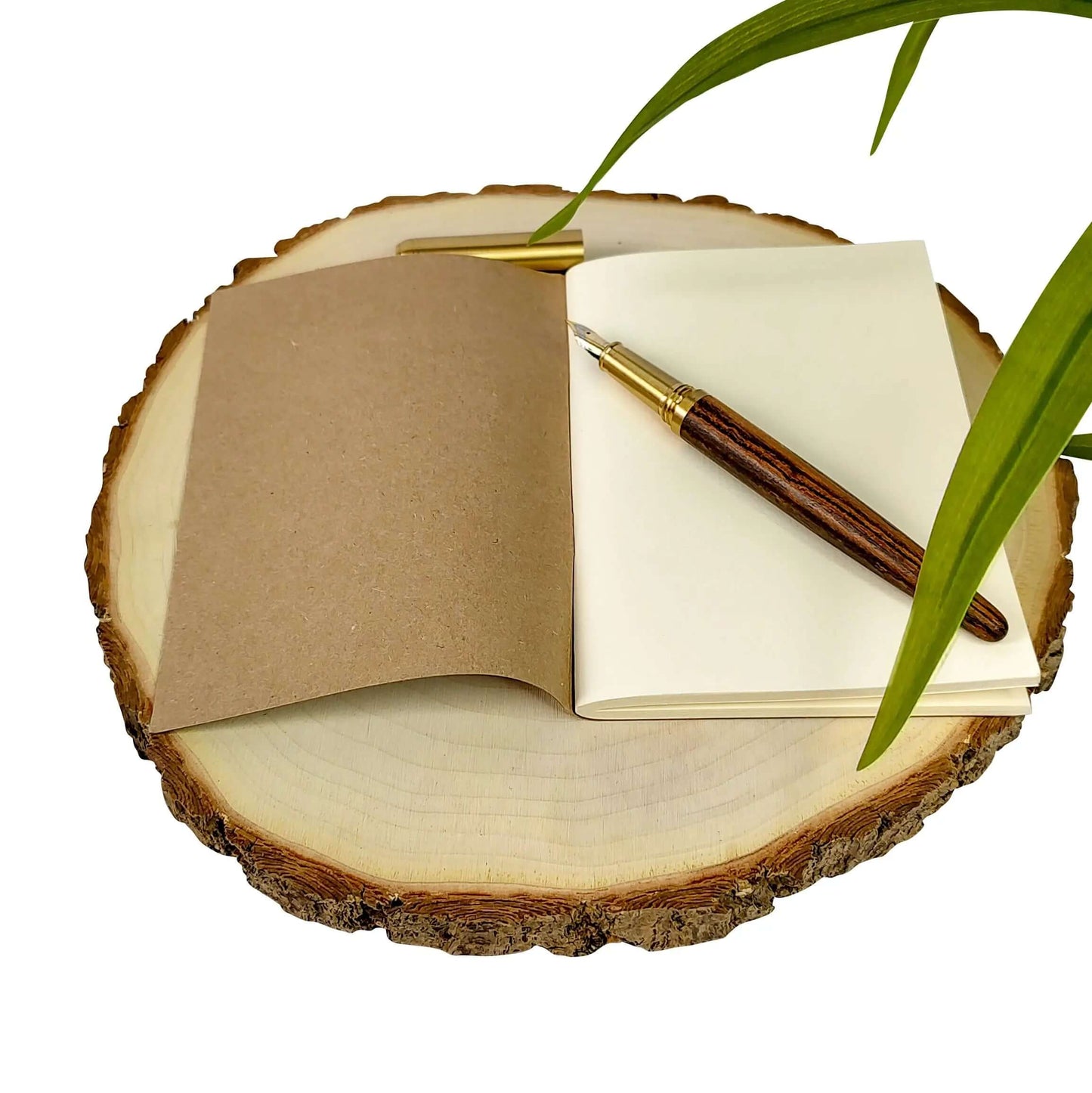 Travel Journal open on a wooden slice with a pen, perfect for documenting adventures and personal reflections.